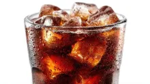 A glass of cola filled with ice cubes, covered in condensation.