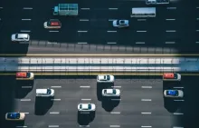 Aerial photograph of cars traveling in multiple lanes on a divided highway.