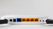 A TP-Link Wi-Fi router with two antennas sitting on a surface.