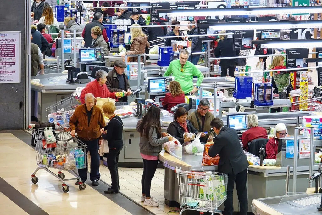 Shoppers waiting in line at a supermarket checkout.